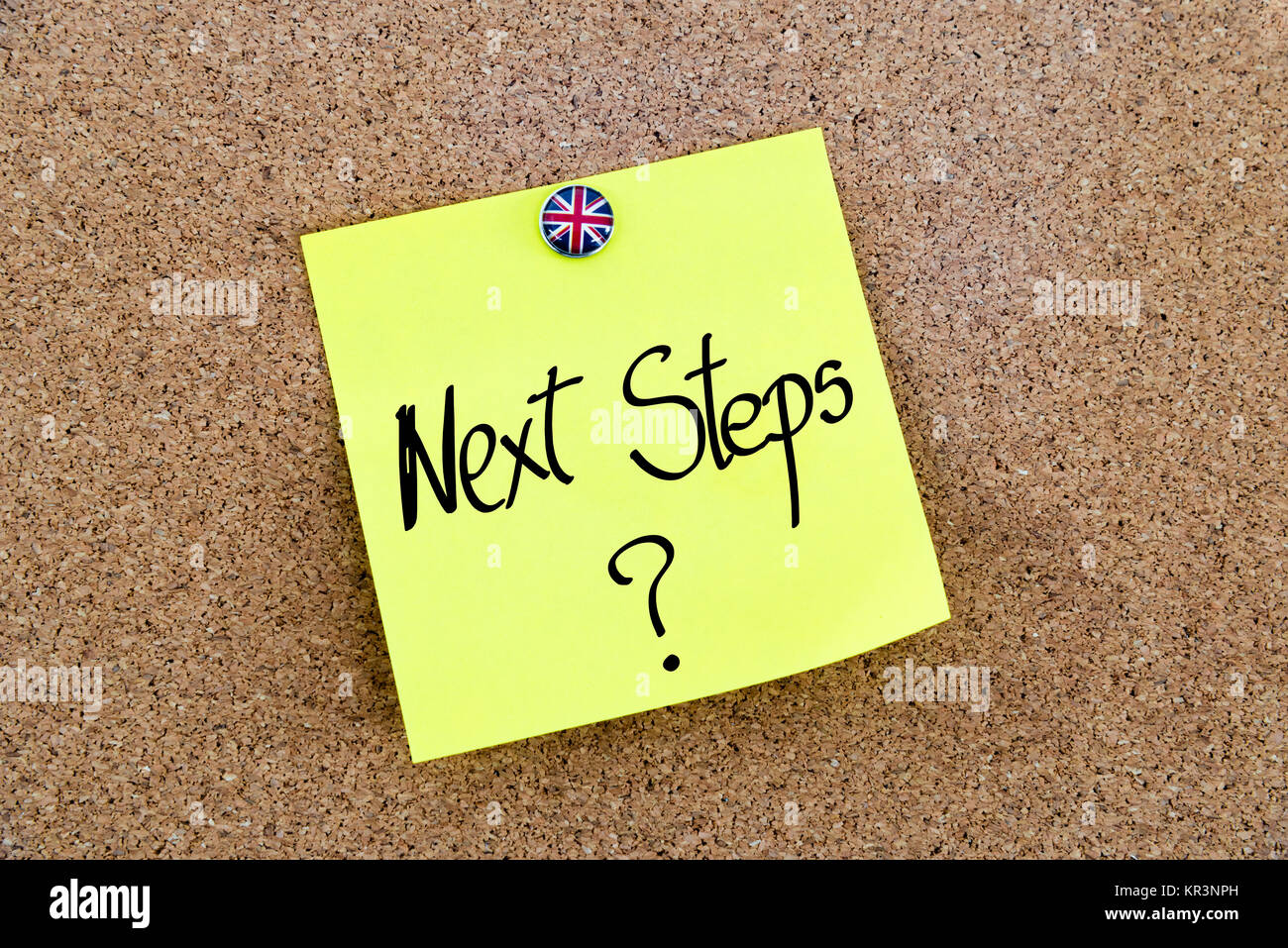 Yellow paper note pinned with Great Britain flag thumbtack and text