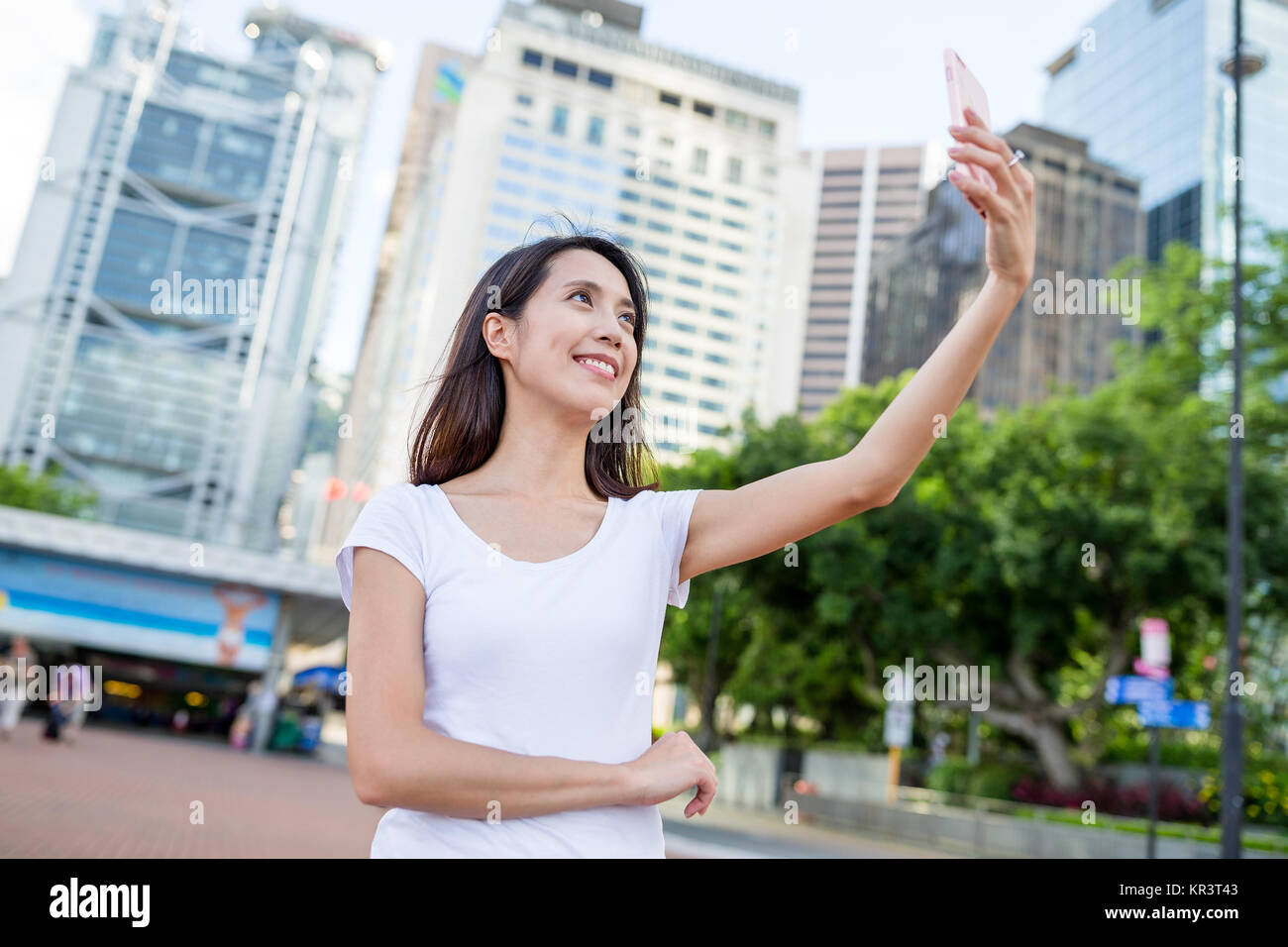 Young woman taking photo in Hong Kong city Stock Photo - Alamy