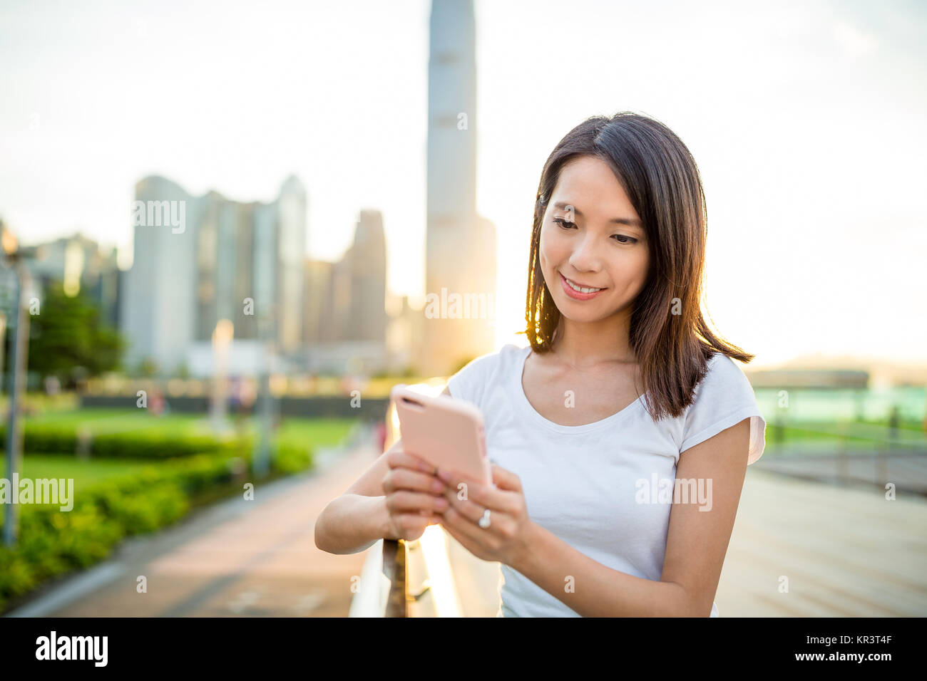Woman using cellphone in Hong Kong city during sunset Stock Photo - Alamy