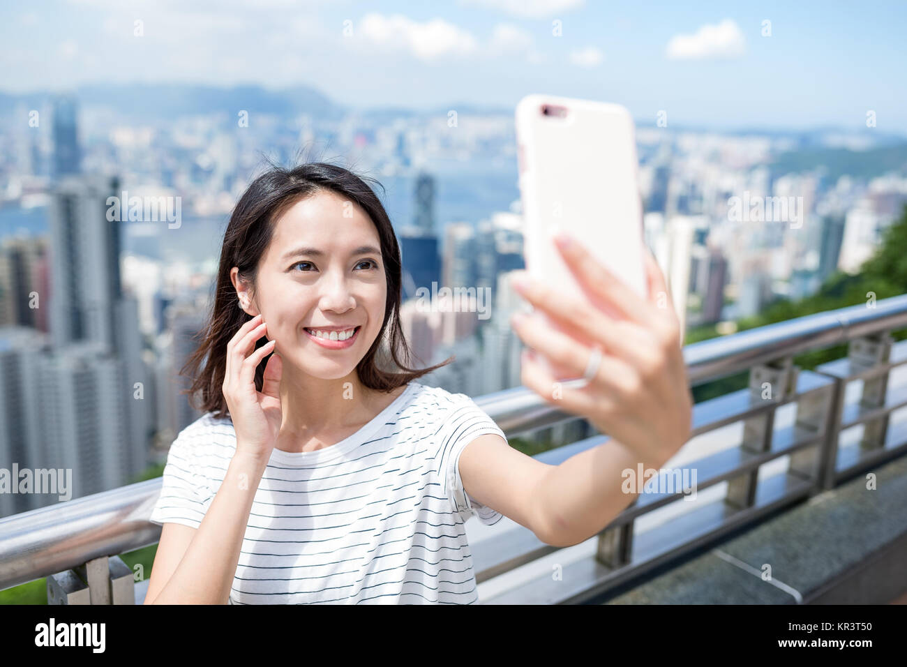 Woman taking selfie by mobile phone in Hong Kong Stock Photo - Alamy