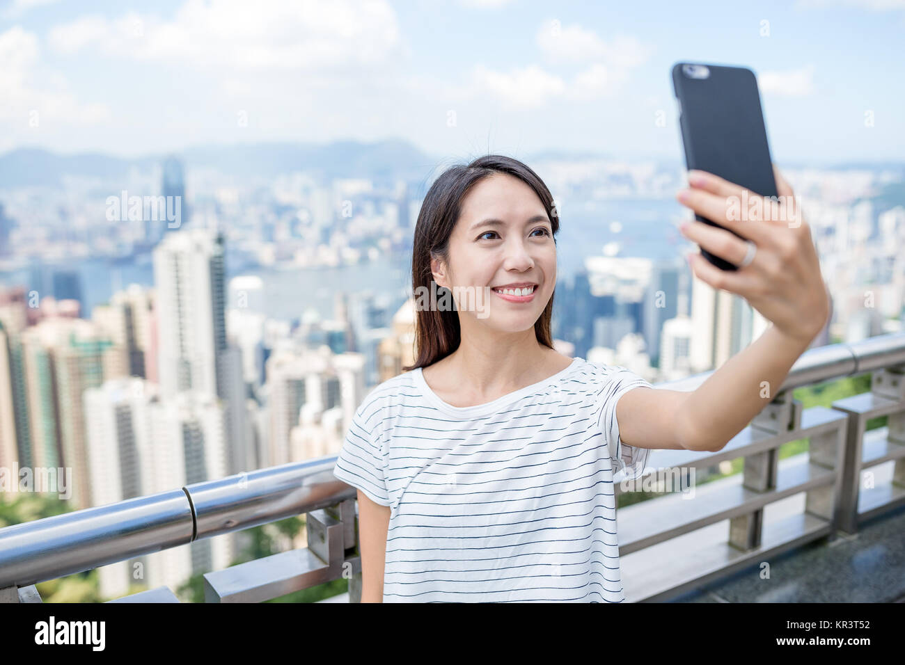 Woman taking selfie by mobile phone in Hong Kong Stock Photo - Alamy
