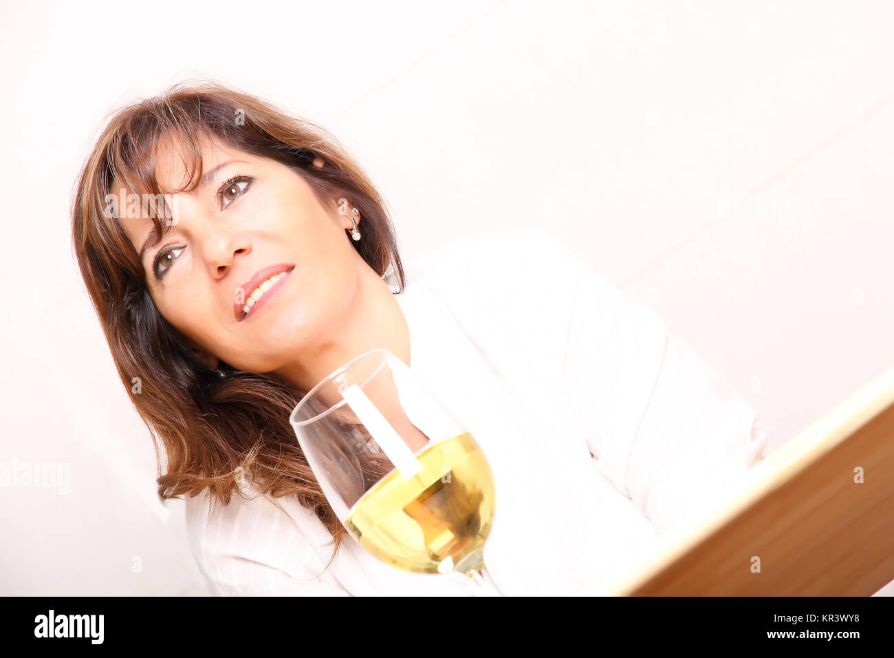 A beautiful mature woman with a glass of white wine Stock Photo - Alamy