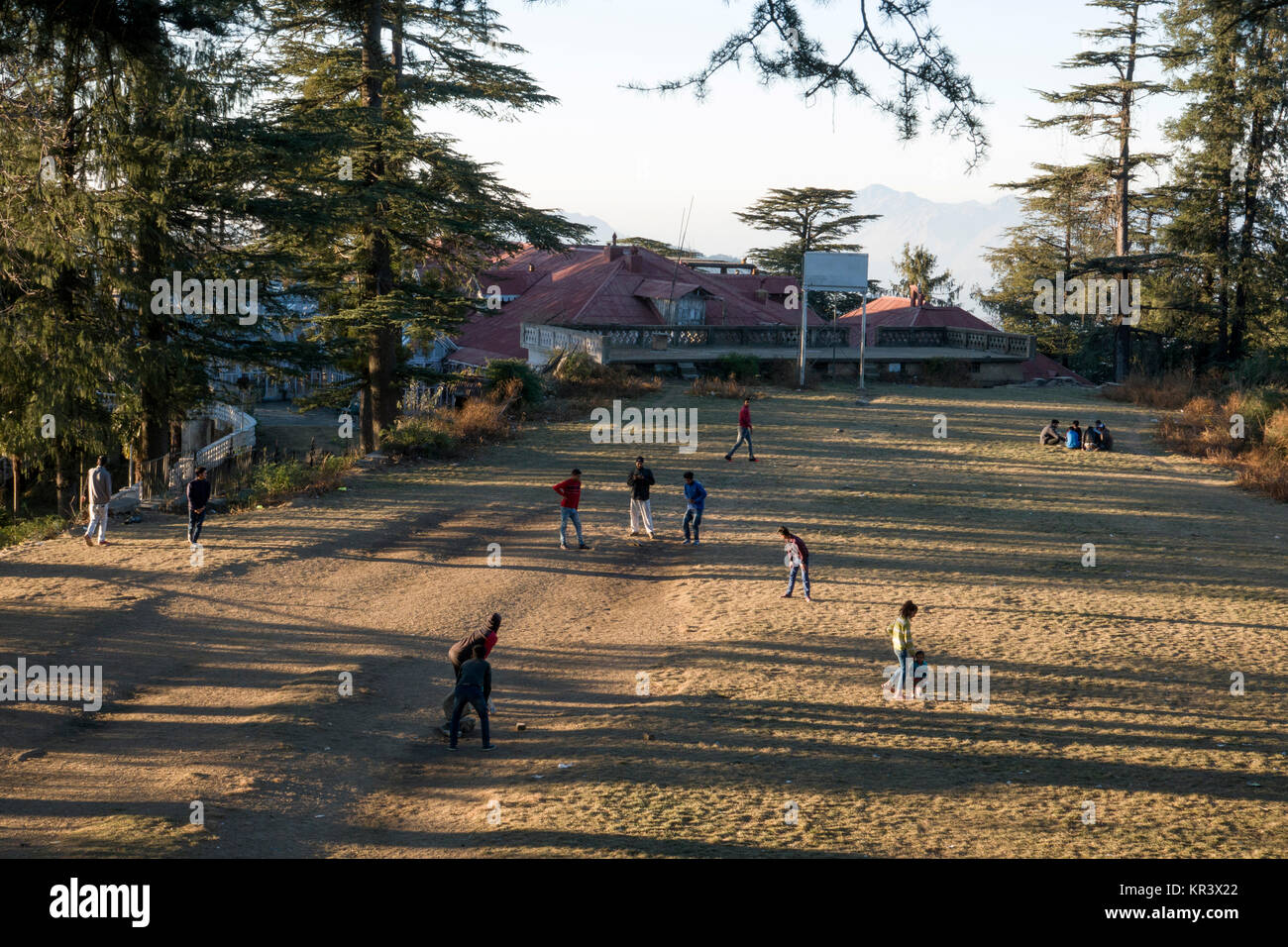 Teenage boys playing game of casual cricket in park at Shimla, India Stock Photo