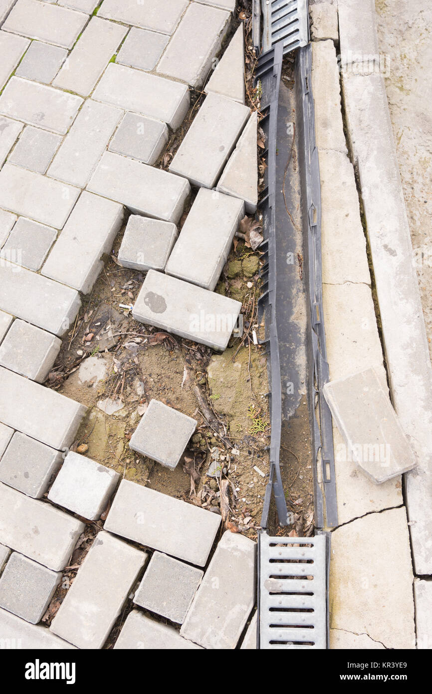 The destruction of the pedestrian walkway of stone tiles with drainage ...