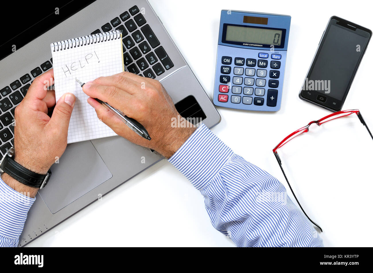 Top view of a man writing on a notepad on the desk in a modern office ...