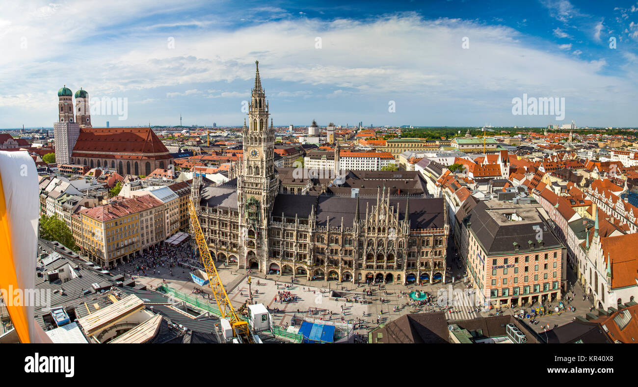 Beautiful super wide-angle sunny aerial view of Munich, Bayern, Bavaria, Germany with skyline and scenery beyond the city, seen from the observation deck of St. Peter Church Stock Photo