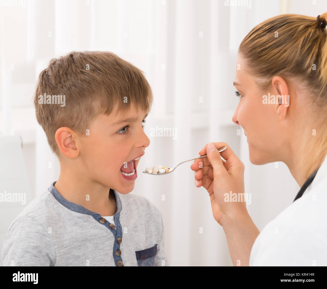 Doctor Giving Medicine To Boy Stock Photo