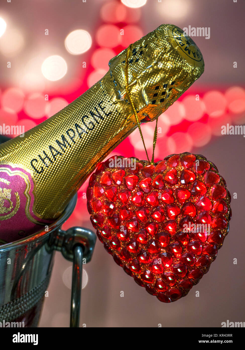 CHAMPAGNE LOVE PARTY LIGHTS Champagne bottle in wine cooler with sparkling love heart and sparkling celebration lights Stock Photo