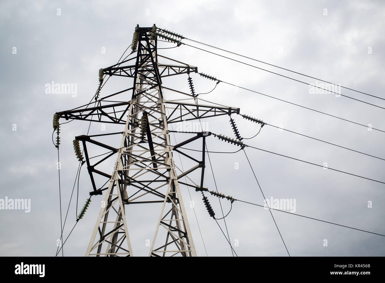 Electricity pylon against cloudy sky Stock Photo - Alamy