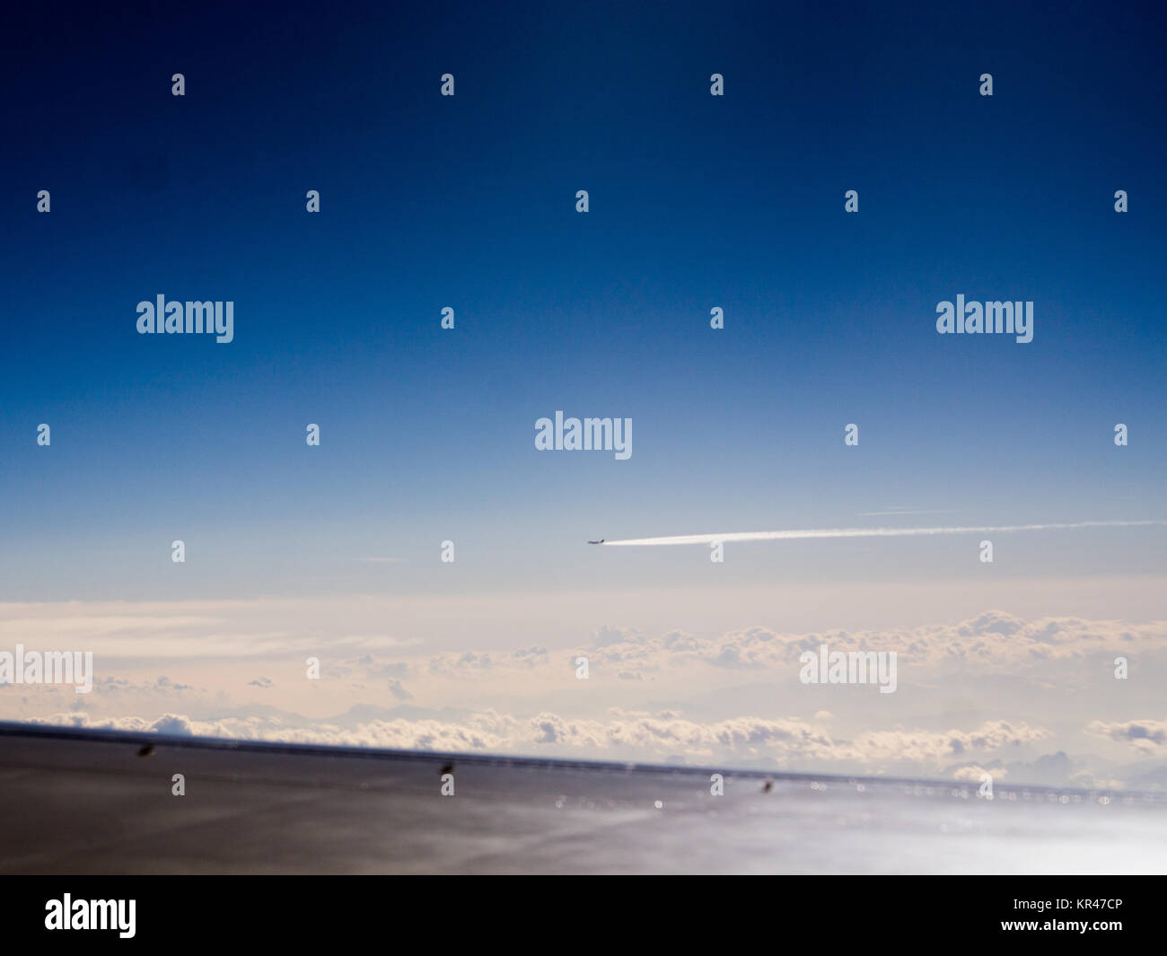 Passenger wide-body plane. Aircraft is flying in blue cloudy sky over the sea. Stock Photo