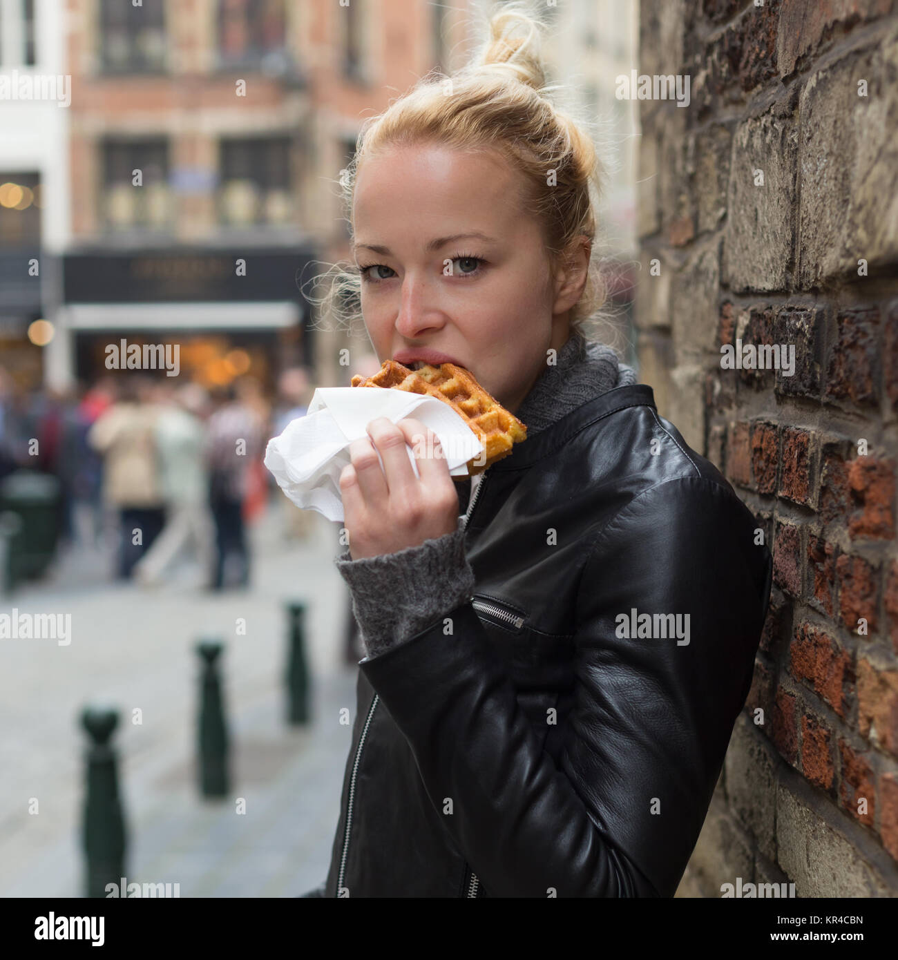 Woman eating belgian waffle on street of Brussels Stock Photo Alamy