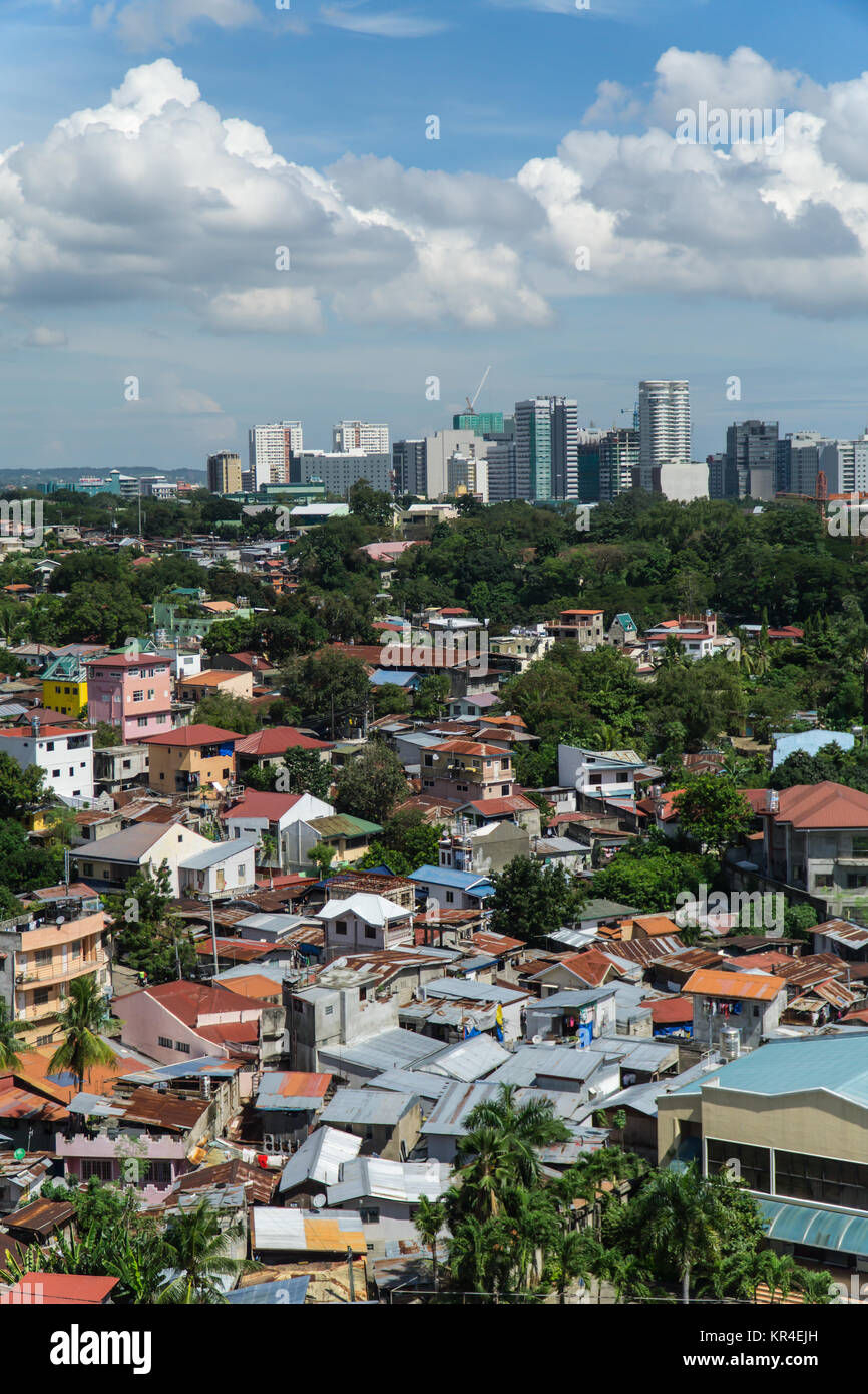 Conecpt image of call centre business growth in the Philippines.The Cebu City I.T. Park buildings forming the skyline with shanti town below Stock Photo