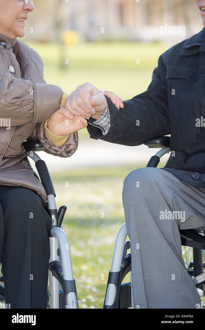 Closeup of hands of elderly couple in wheelchairs Stock Photo Alamy