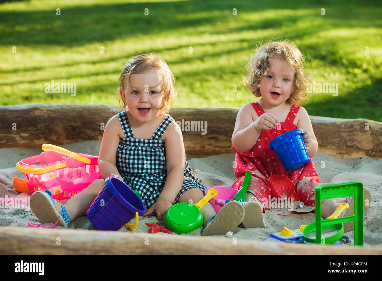 The two little baby girls playing toys in sand Stock Photo - Alamy