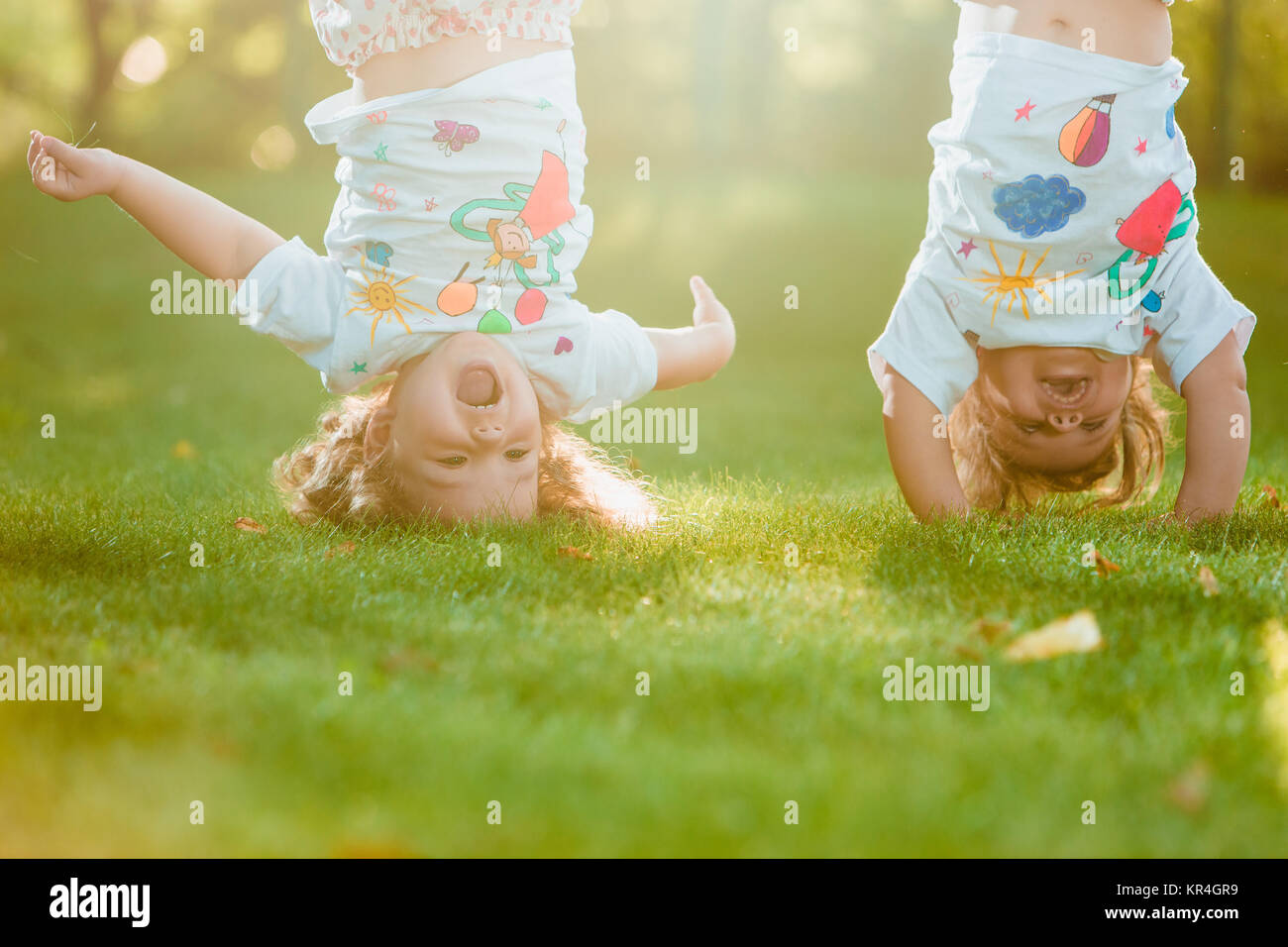 The two little baby girls hanging upside down Stock Photo Alamy