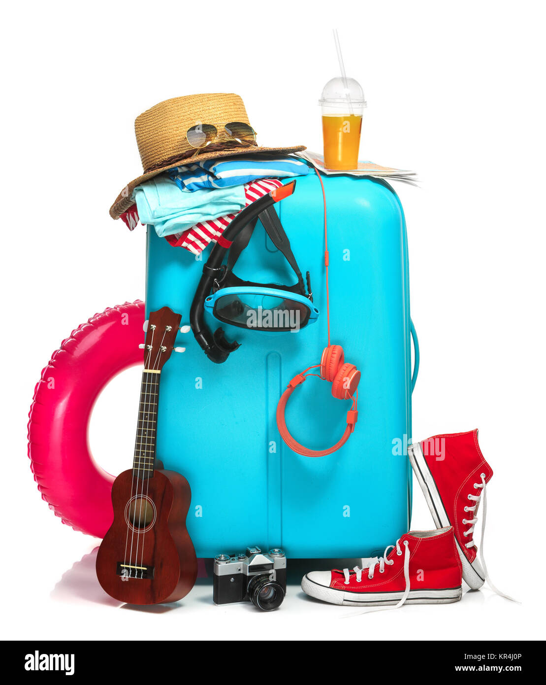 The blue suitcase, sneakers, hat and rubber ring on white background. Stock Photo