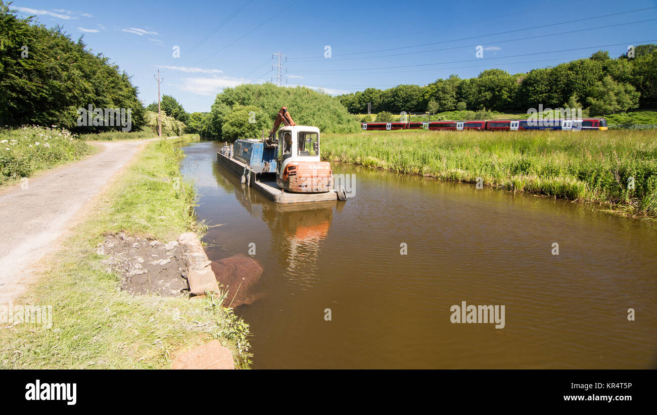Leeds, England - June 30, 2015: A Northern Rail Class 333 commuter train runs alongside the Leeds and Liverpool Canal near Shipley in West Yorkshire's Stock Photo