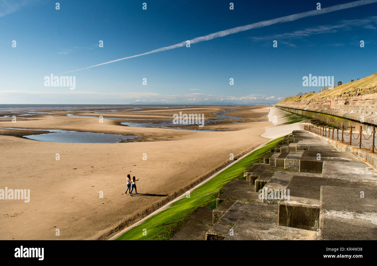 Blackpool, England, UK - August 1, 2015: Two women walk on Blackpool Beach on a summer afternoon. Stock Photo