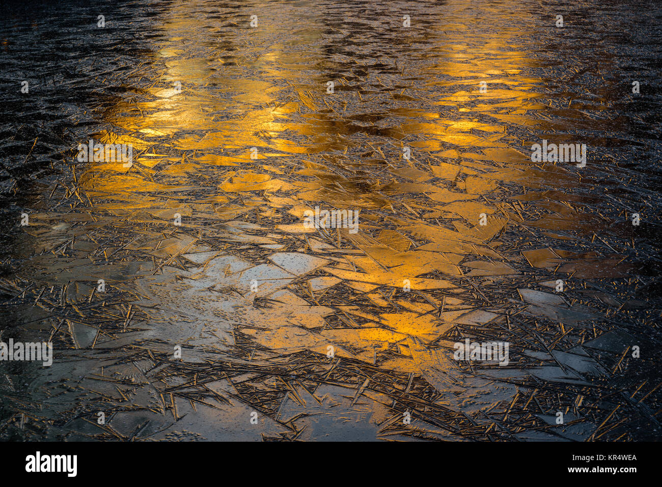 Abstract orange sunrise or sunset reflecting on lake ice. Stock Photo