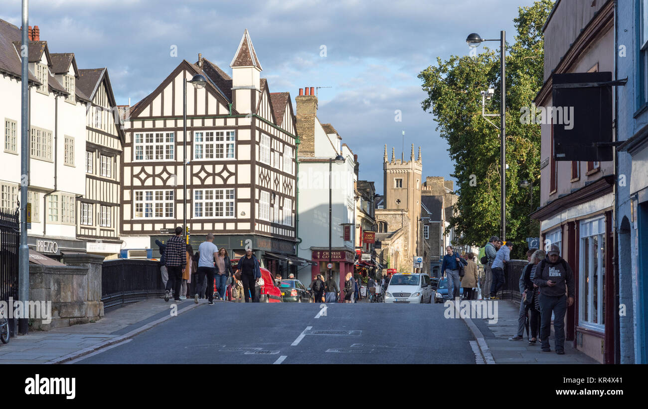Cambridge, England, UK - August 19, 2017: Traditional shops and houses line Bridge Street in the city centre of Cambridge, with the tower of St Clemen Stock Photo