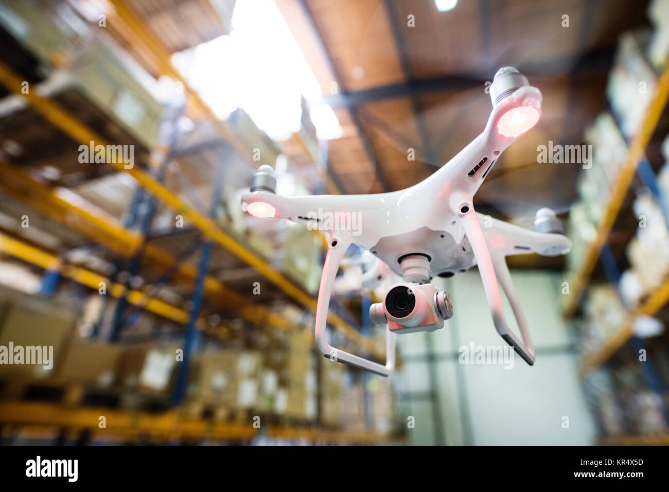 White drone flying inside the warehouse. Stock Photo