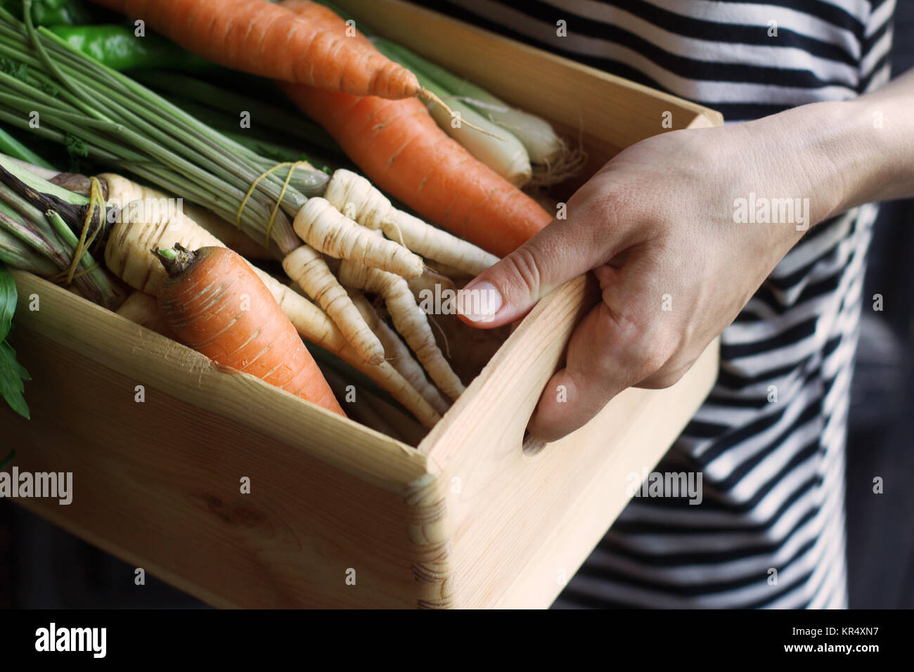 Woman holding a wooden crate full of vegetables at the market Stock ...