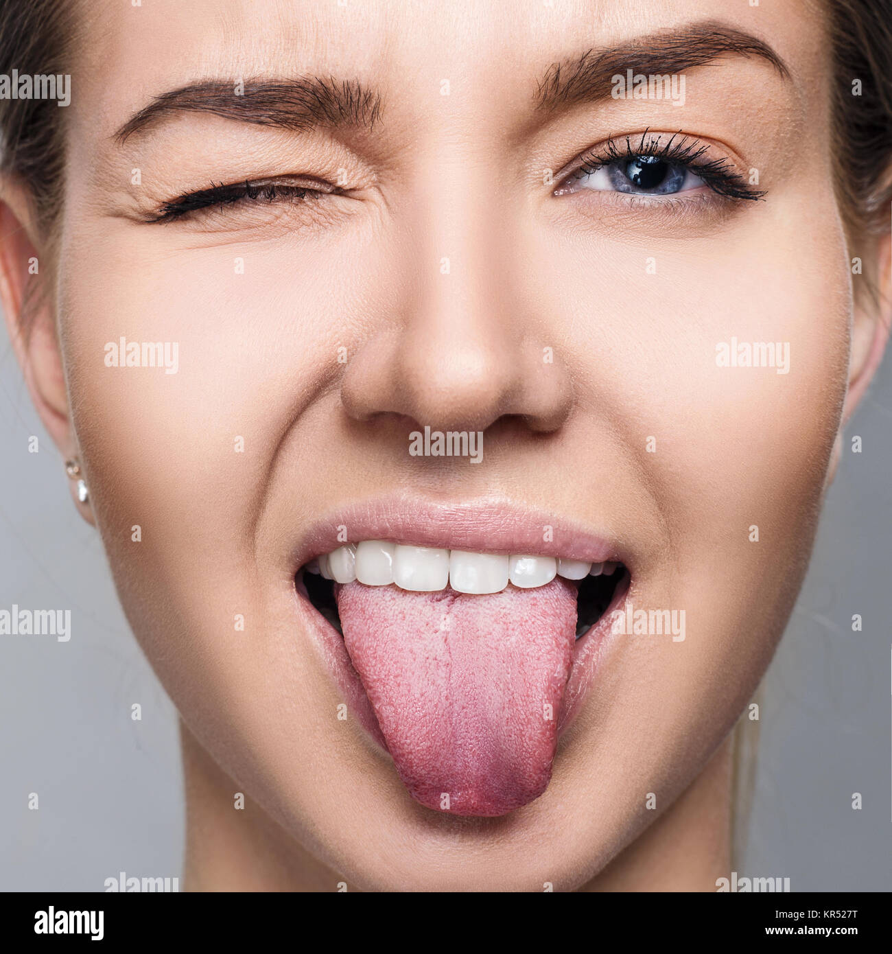 Close-up portrait of woman shows tongue grimace. Stock Photo