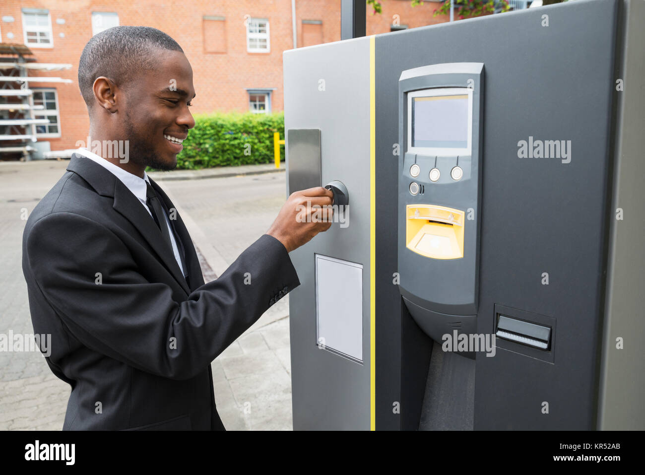 Businessman Inserting Coin Into Parking Meter Stock Photo Alamy