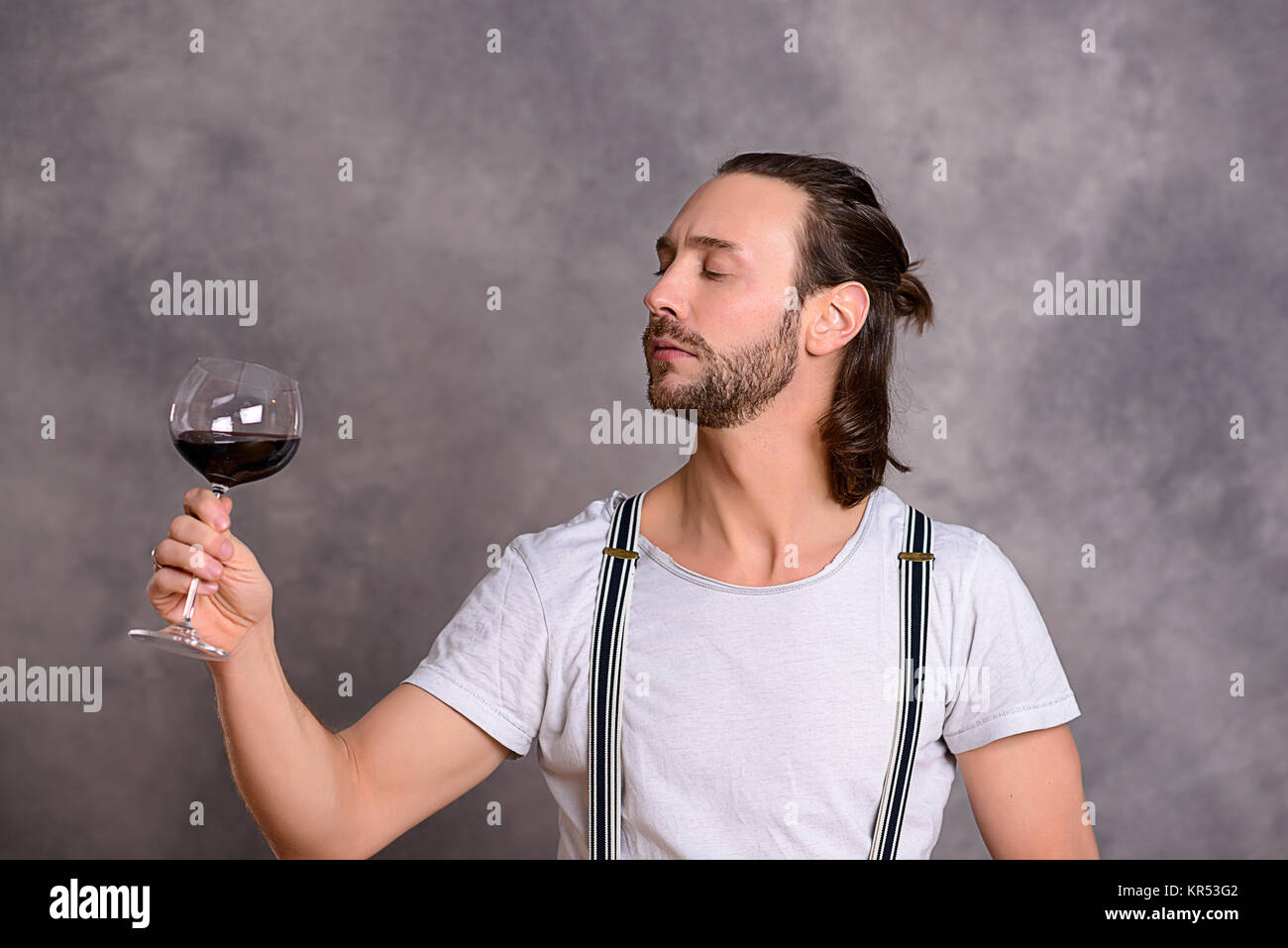 young man in front of gray background drinking red wine Stock Photo - Alamy
