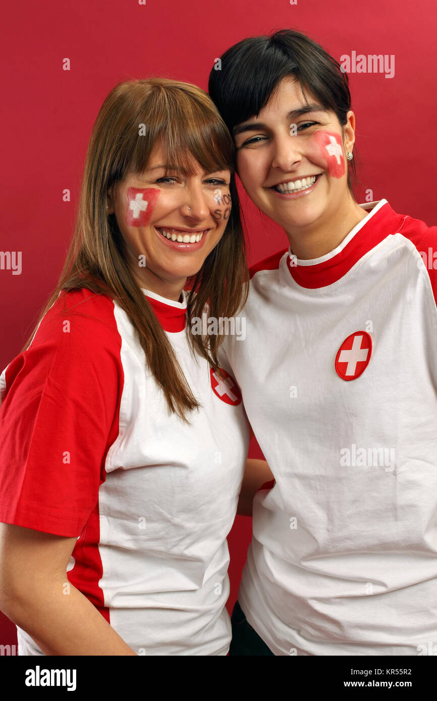 Photo of two female Swiss sports fans smiling and cheering for their