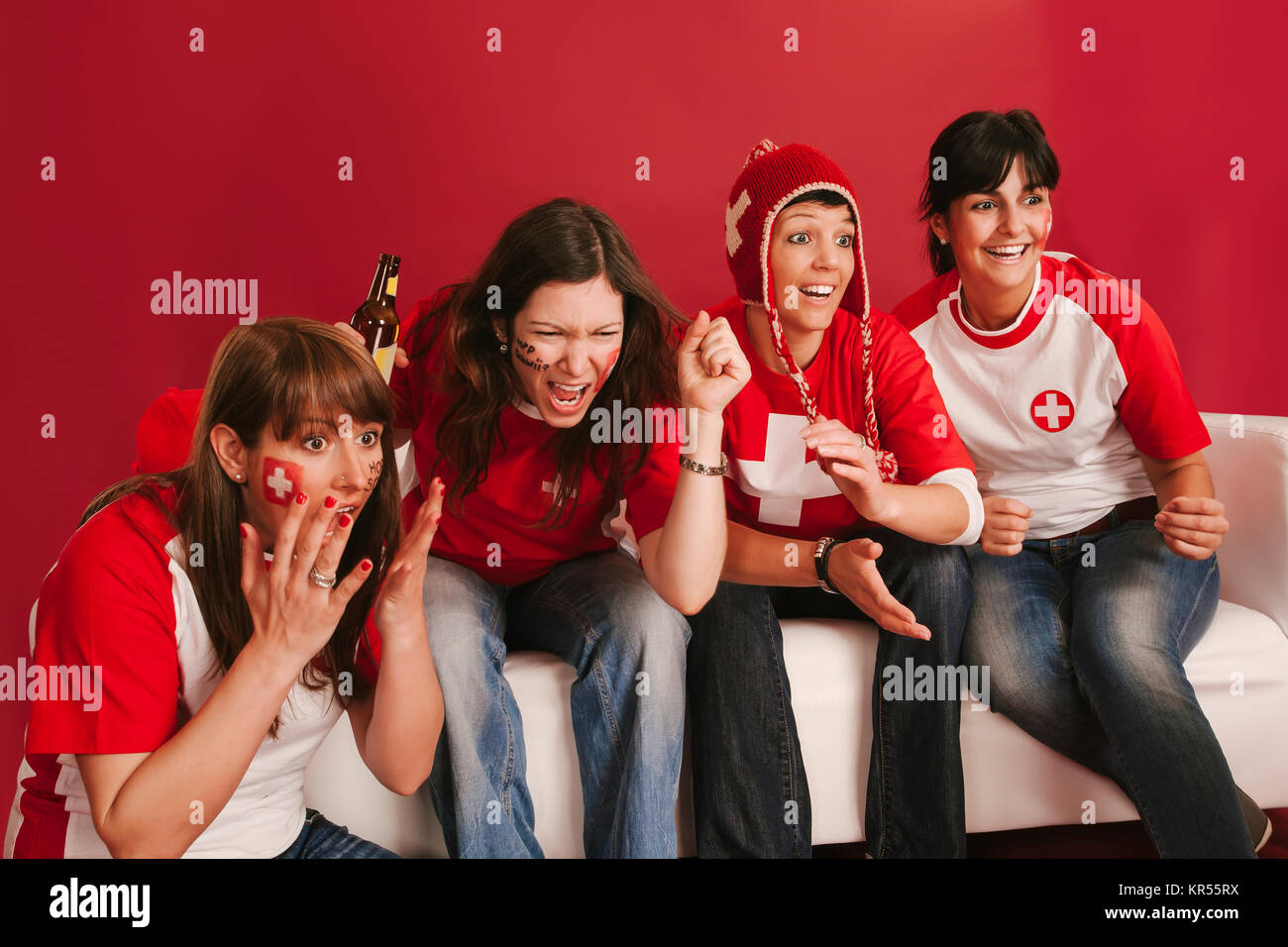 Photo of female Swiss sports fans watching television and cheering for