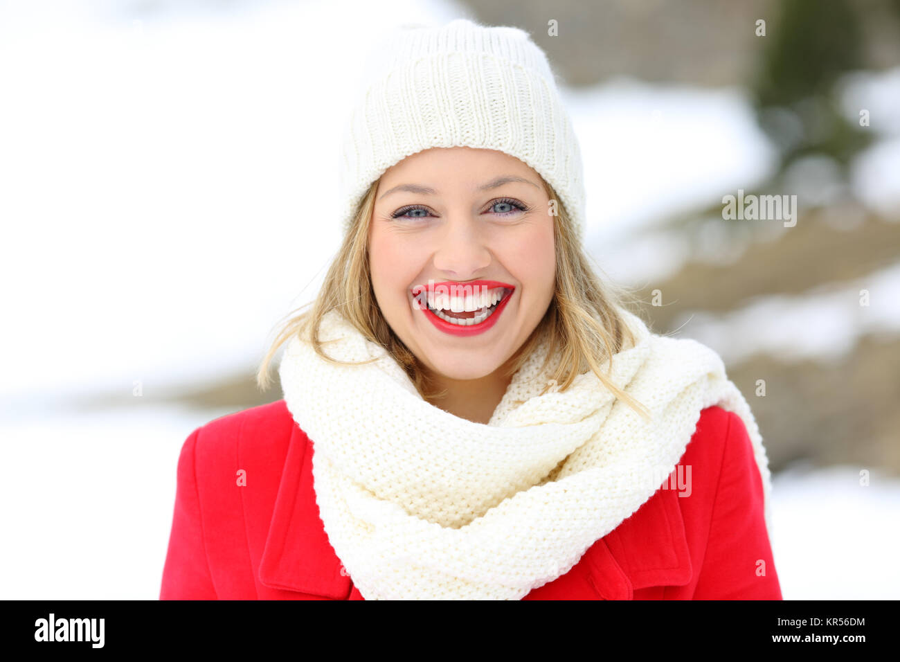 Front view portrait of a beauty blonde laughing looking at you in winter in the snowy mountain Stock Photo