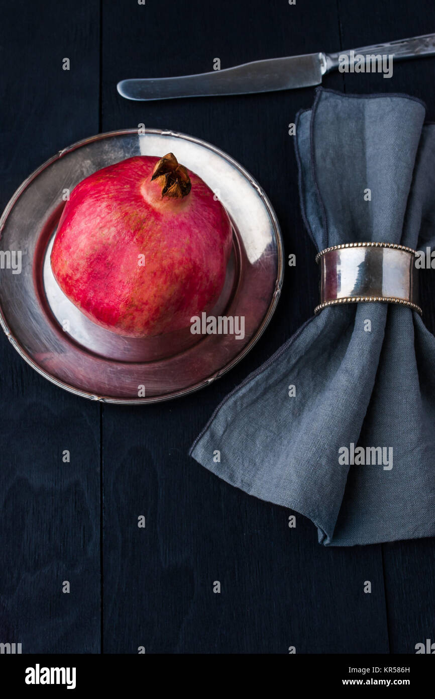 Pomegranate with old vintage dinnerware Stock Photo