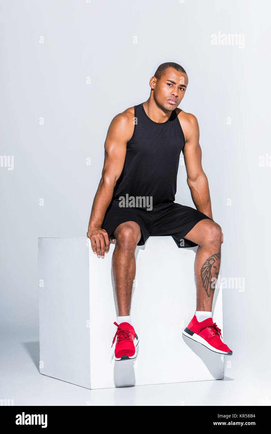 full length view of young african american sportsman sitting Stock ...