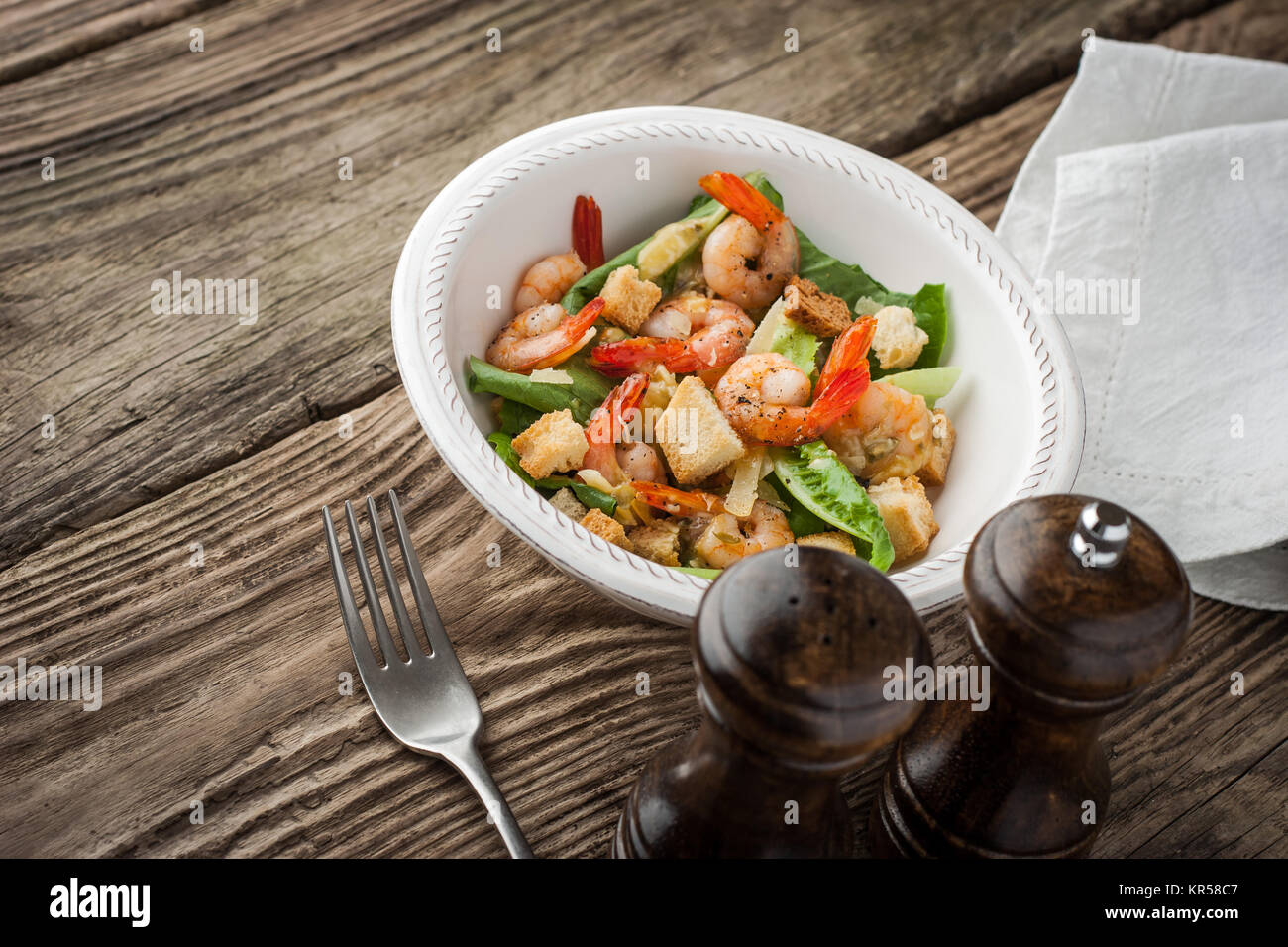 Prawns Caesar salad with fork on the wooden table horizontal Stock Photo