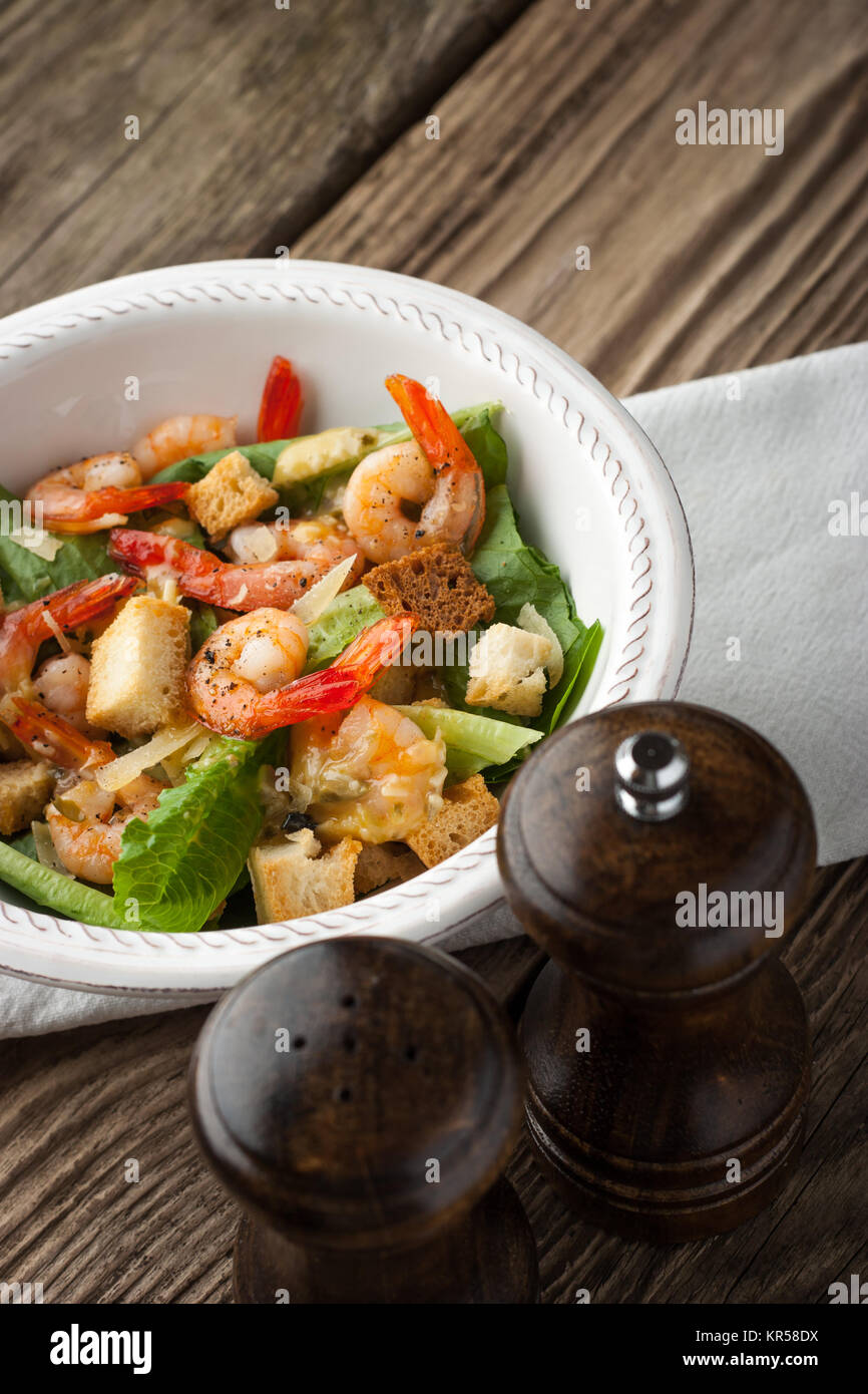 Caesar salad with shrimps on the wooden table Stock Photo