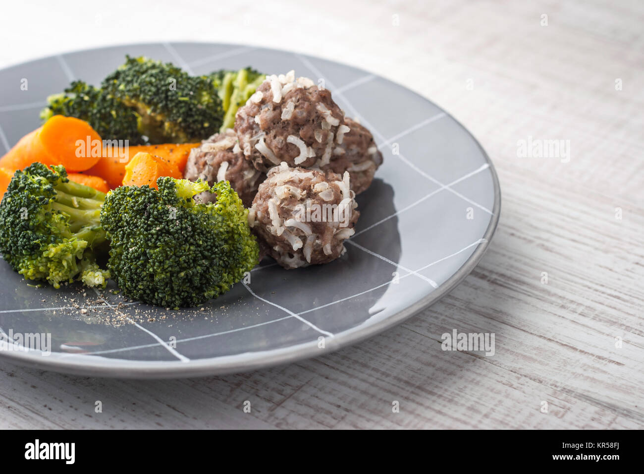 Steamed vegetables with meatballs on the gray plate Stock Photo