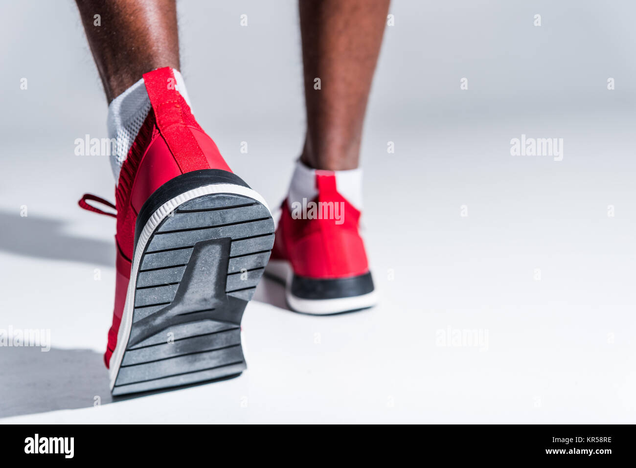 selective focus of african american sportsman in sneakers on grey Stock Photo