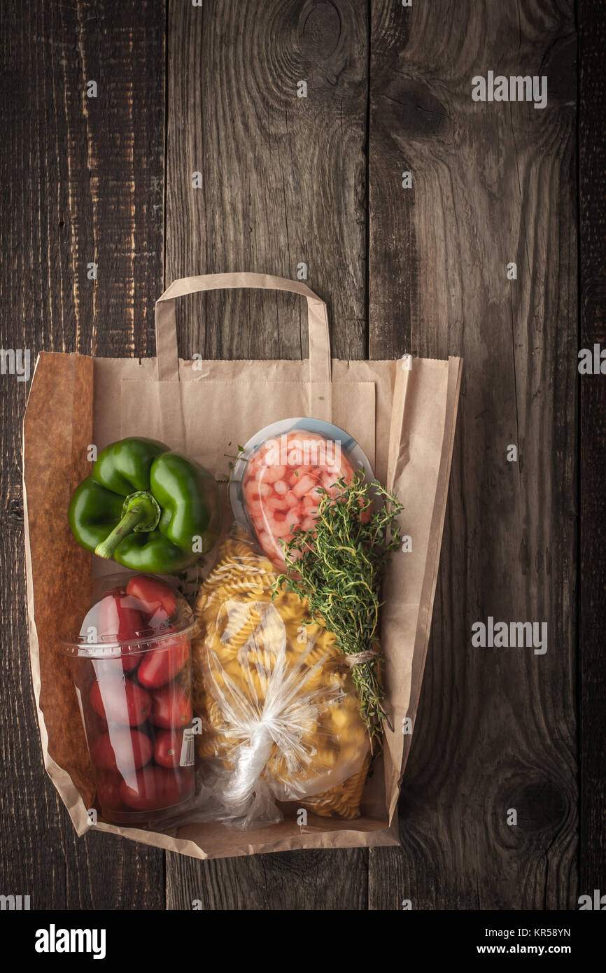 Food mix  inside a paper bag on the wooden background vertical Stock Photo