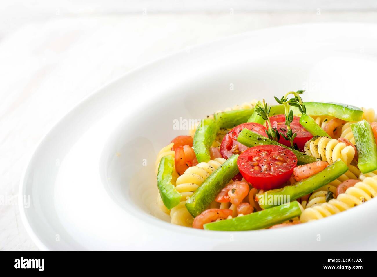 Pasta with vegetables and shrimps on the white plate horizontal Stock Photo