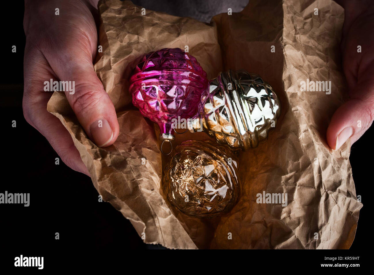 Hands with Christmas tree decorations in wrapping paper Stock Photo