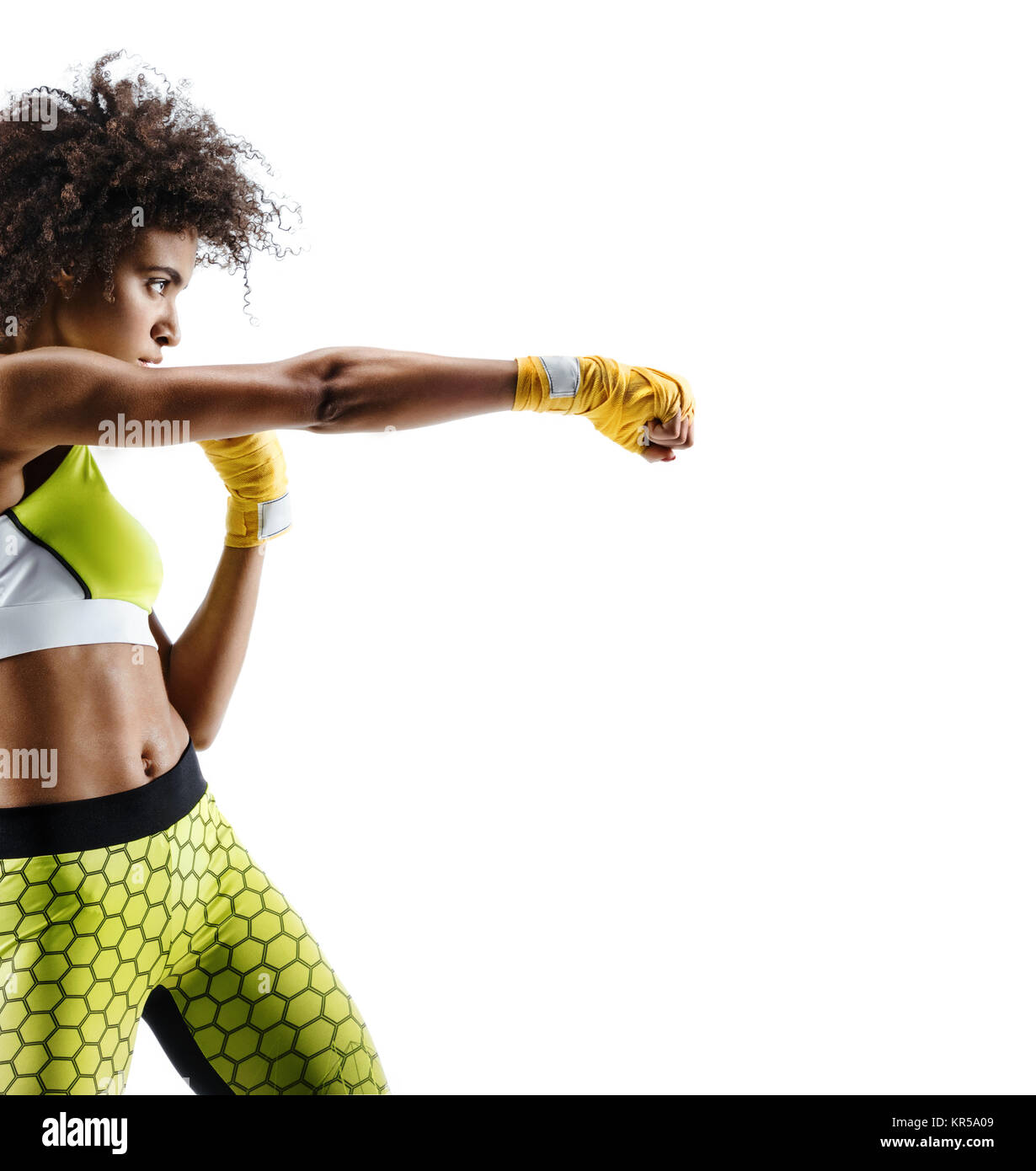 Boxer woman in yellow bandages making direct hit. Photo of sporty african woman during boxing on white background. Dynamic movement. Side view Stock Photo