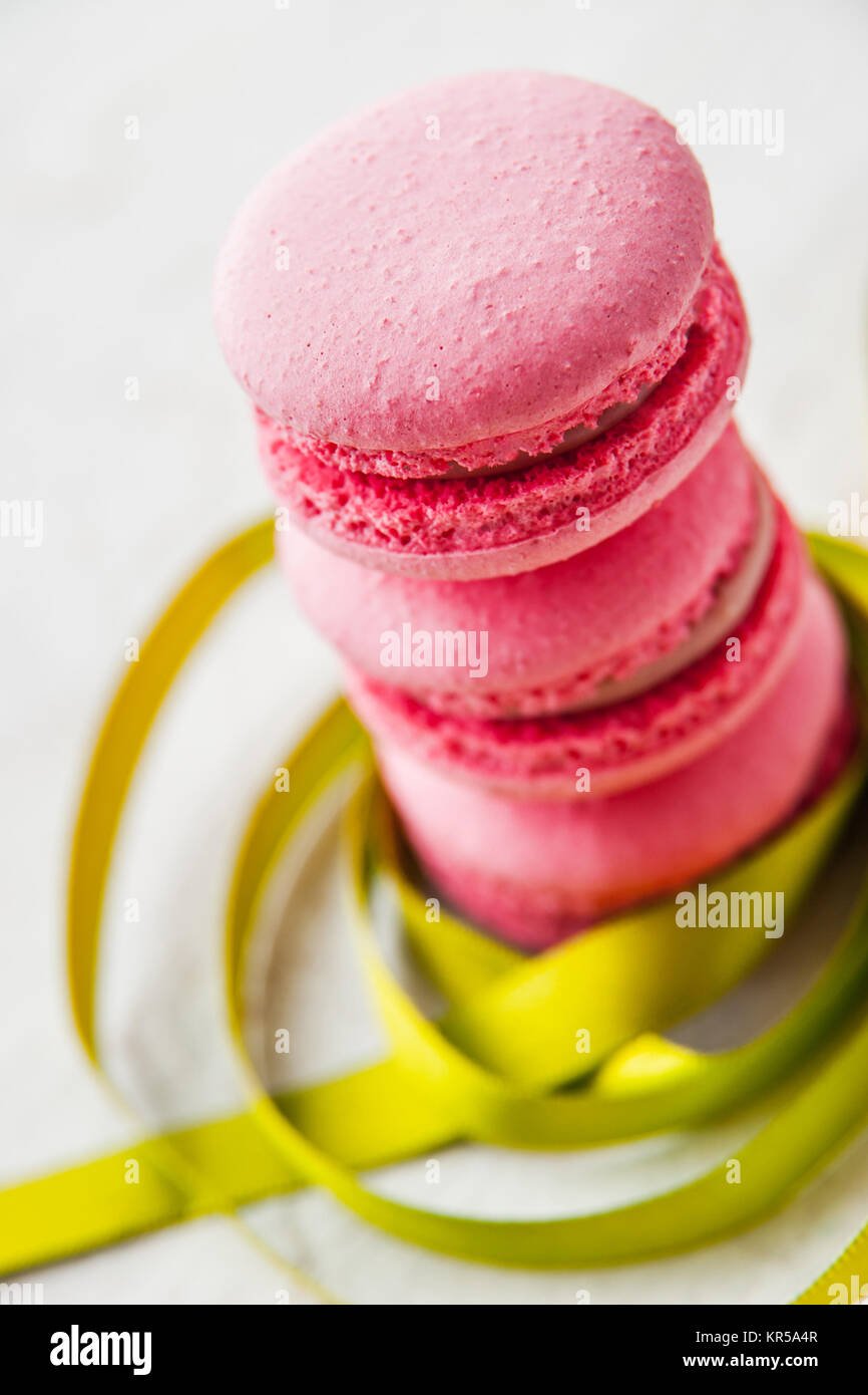 Pink macaroon on a white background with green ribbon Stock Photo