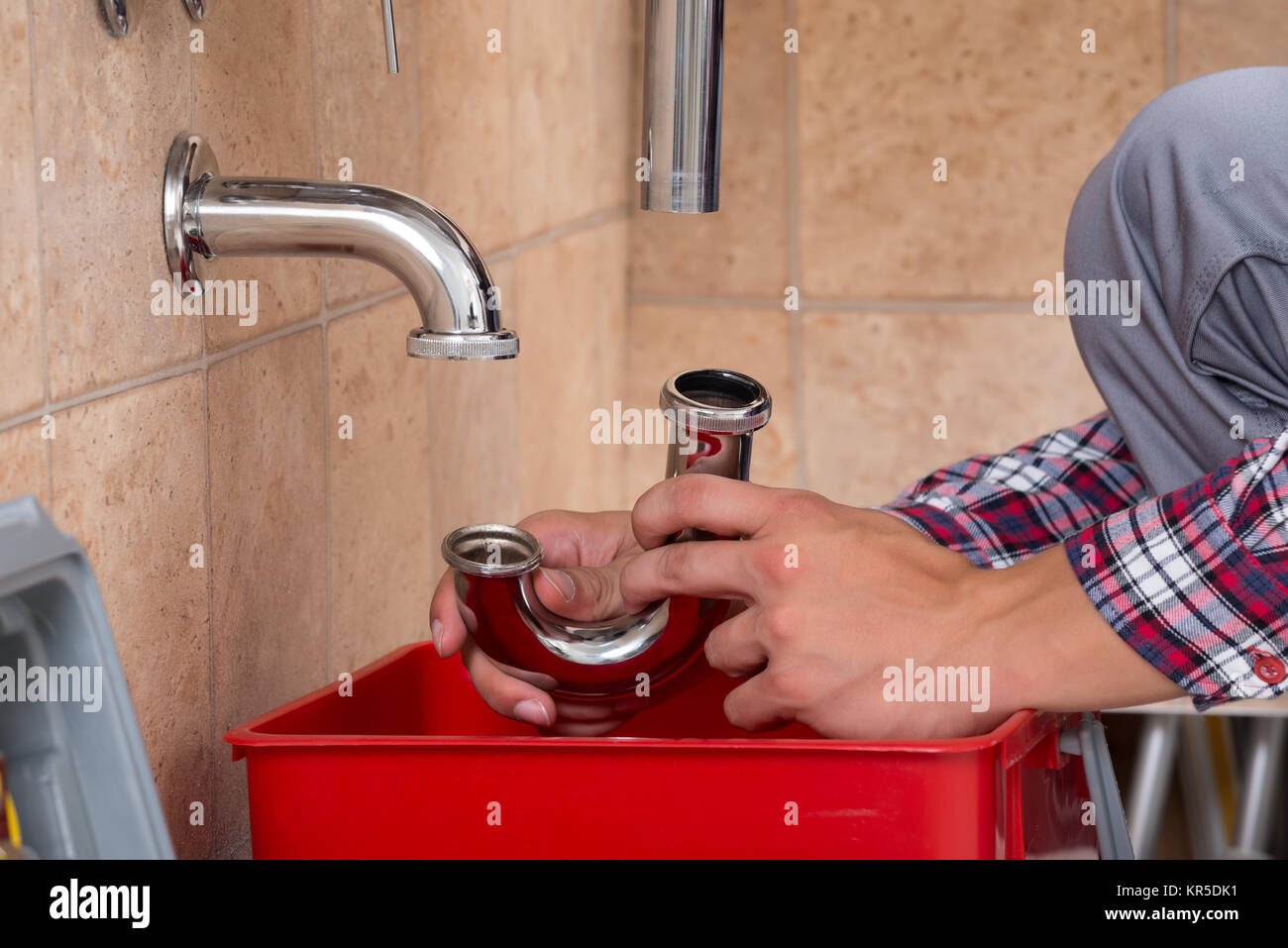 https://c8.alamy.com/comp/KR5DK1/plumbers-hand-fixing-sink-in-bathroom-KR5DK1.jpg