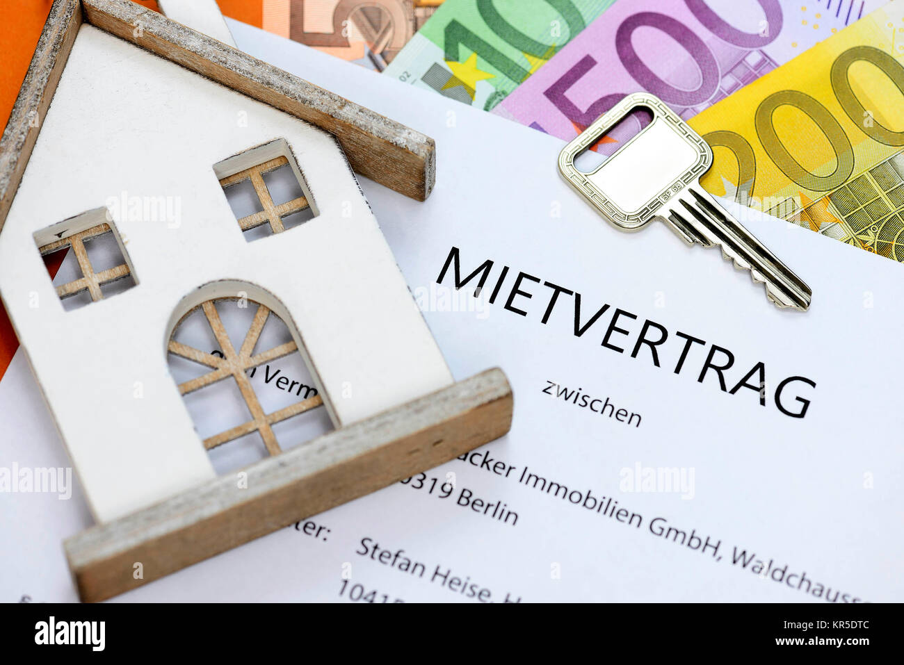Hire contract with front door key and bank notes, Mietvertrag mit Haustürschlüssel und Geldscheinen Stock Photo