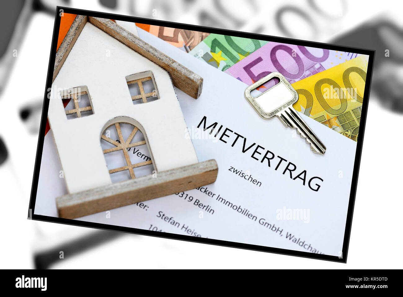 Hire contract with front door key and bank notes, Mietvertrag mit Haustürschlüssel und Geldscheinen Stock Photo