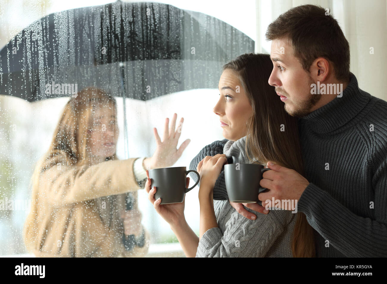 Stalker ex girlfriend disturbing to a couple that is relaxing looking through a window in a coffee shop Stock Photo