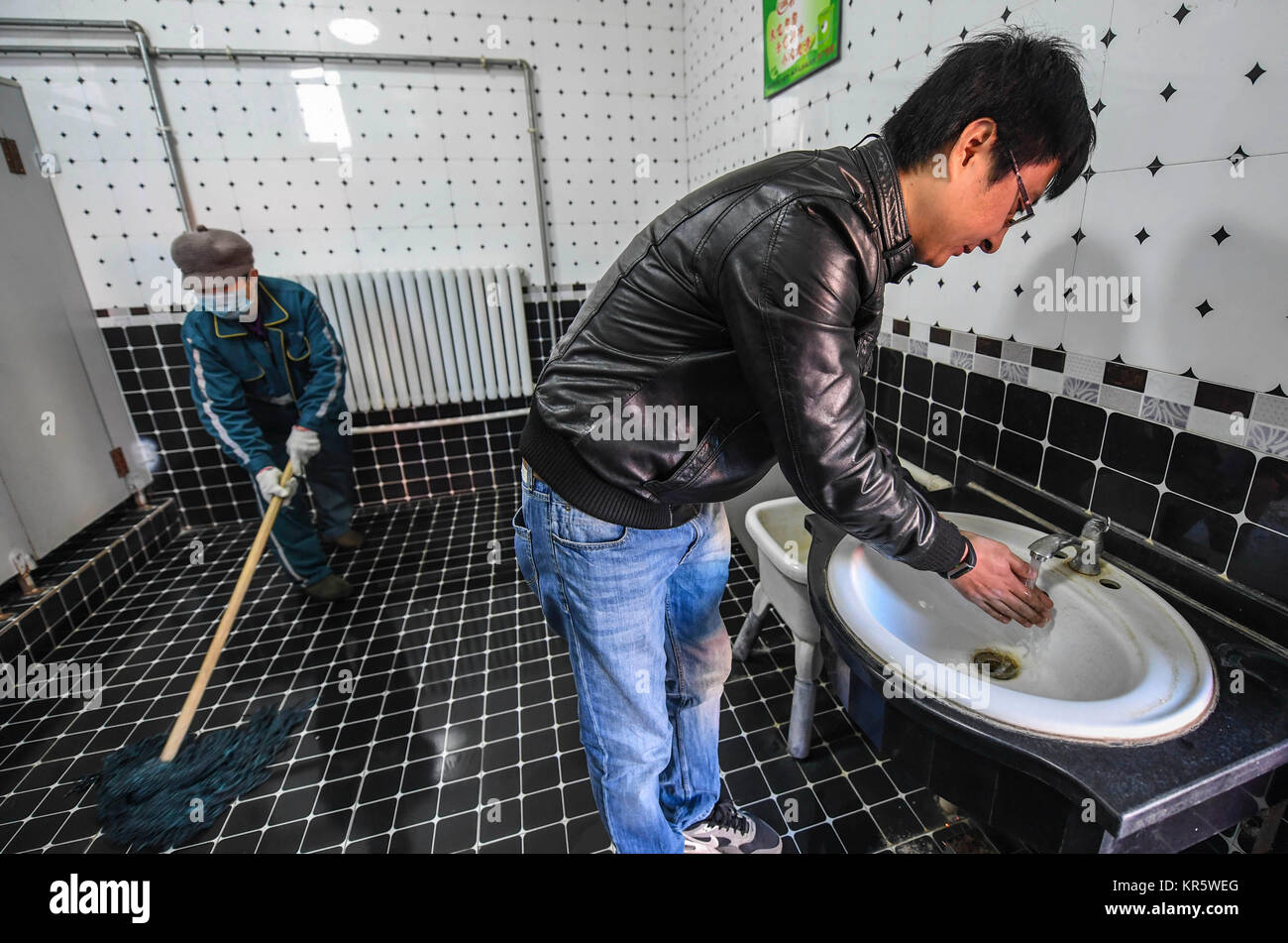 (171218) -- DACHANG, Dec. 18, 2017 (Xinhua) -- A man washes hands at a public toilet in Dachang Hui Autonomous County, north China's Hebei Province, Dec. 18, 2017. Dachang has added cleaners to ensure the cleaness of public restrooms in the county. (Xinhua/Li Xiaoguo) (xzy) Stock Photo