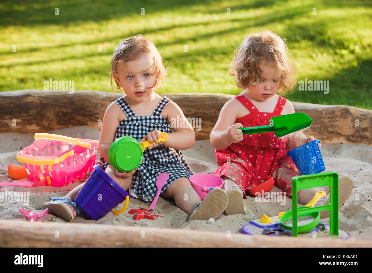 The two little baby girls playing toys in sand Stock Photo - Alamy