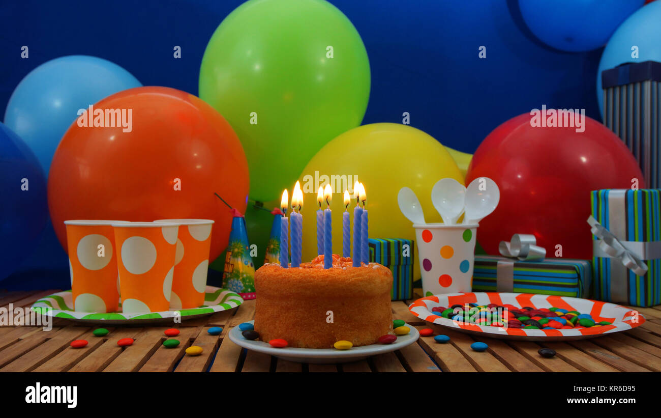 Birthday cake with a blue candles burning on rustic wooden table Stock ...